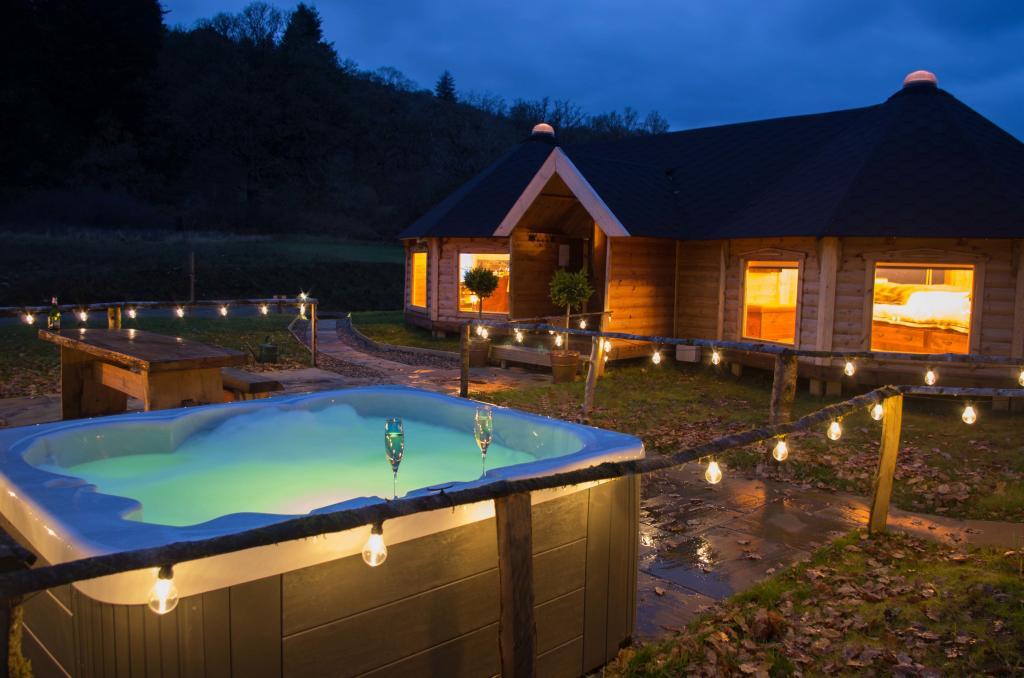 Showing a camping cabin at night with a hot tub outside